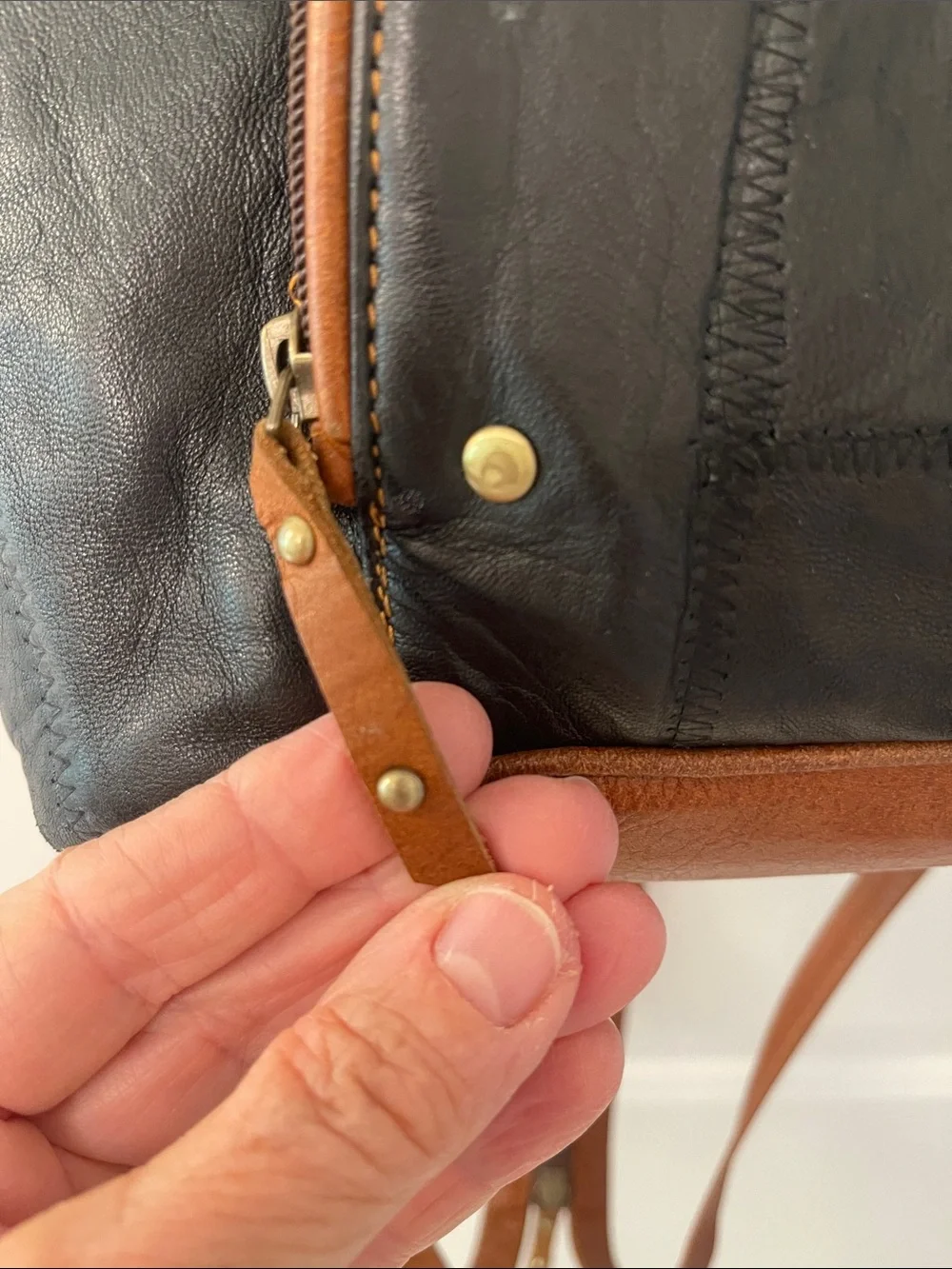 Black Leather Backpack with Brown Trim and Brass Accents